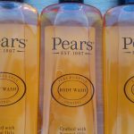 Three bottles of pear’s body wash on a table.