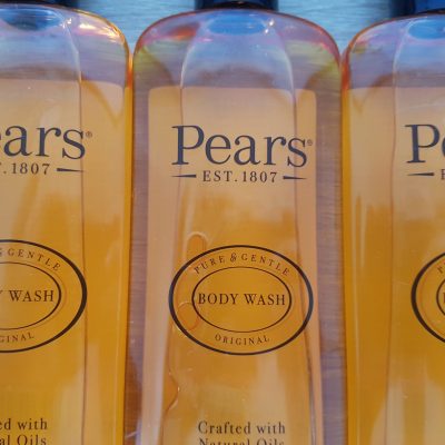 Three bottles of pear's body wash on a table.