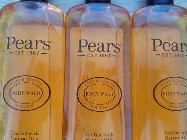 Three bottles of pear's body wash on a table.