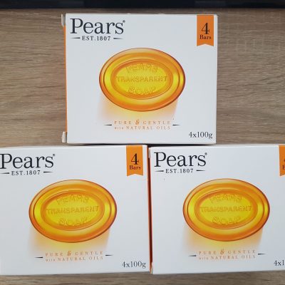 Three boxes of pears's facial soap on a wooden table.