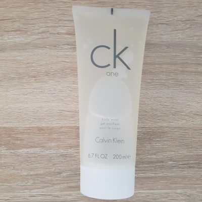 A tube of ck cream sitting on a wooden table.