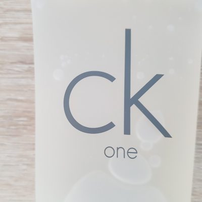 A bottle of ck one on a wooden table.