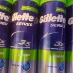Three cans of gillette series are lined up on a shelf.
