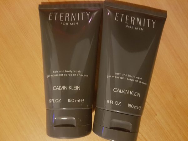 Two tubes of calvin klein eternity face wash on a wooden table.