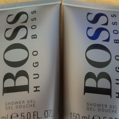 Two bottles of hugo boss shower gel on a table.