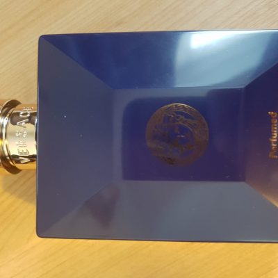 A blue perfume bottle on a wooden table.