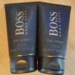 Two tubes of boss the scent on a wooden table.