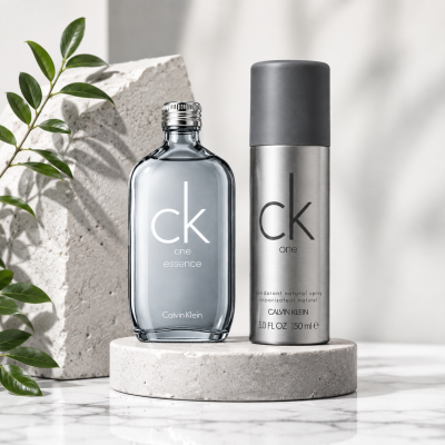 The CK One 100ml EDT & CK One Body Wash Gift Bundle Set is displayed on a round stone platform with a leafy branch and textured stone background.