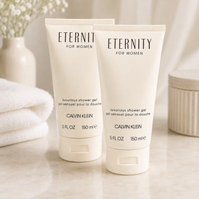 Two tubes of 2x Calvin Klein Eternity for Women, 150ml Shower Gel are placed on a bathroom counter next to folded white towels and a container.