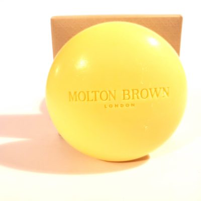 A yellow ball with the word Molton Brown Orange & Bergamot Perfumed Bar of Soap, 150g on it.