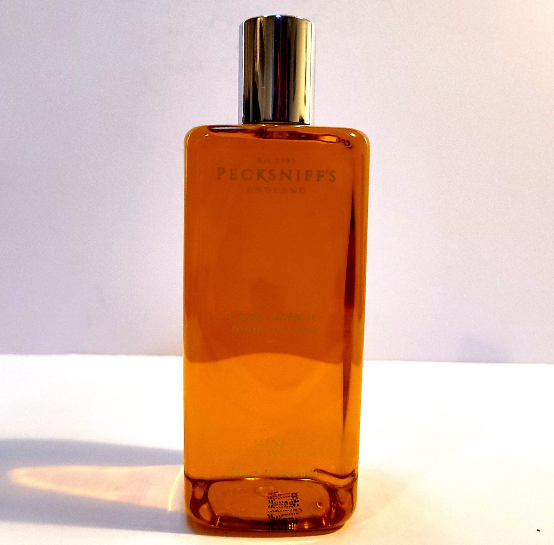 A bottle of Pecksniffs Charismatic Mens Bath & Shower Gel, 500ml sitting on a white surface.