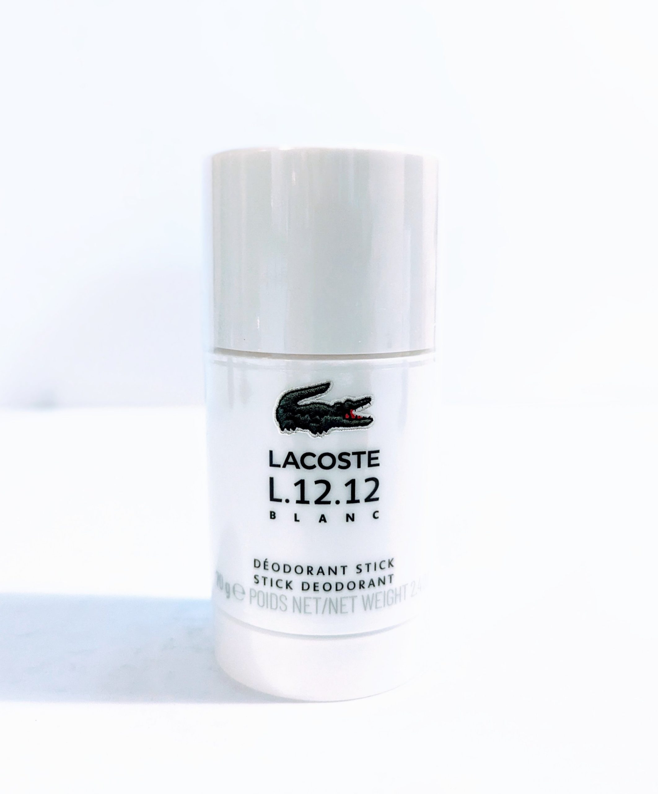 A bottle of Lacoste L.12.12 Blanc Pure Deodorant Stick for Men on a white surface.
