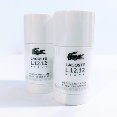 Two Lacoste L.12.12 Blanc Pure Deodorant Stick for Men on a white surface.
