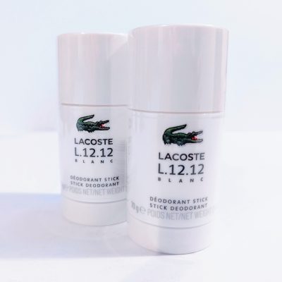 Two Lacoste L.12.12 Blanc Pure Deodorant Sticks on a white surface.