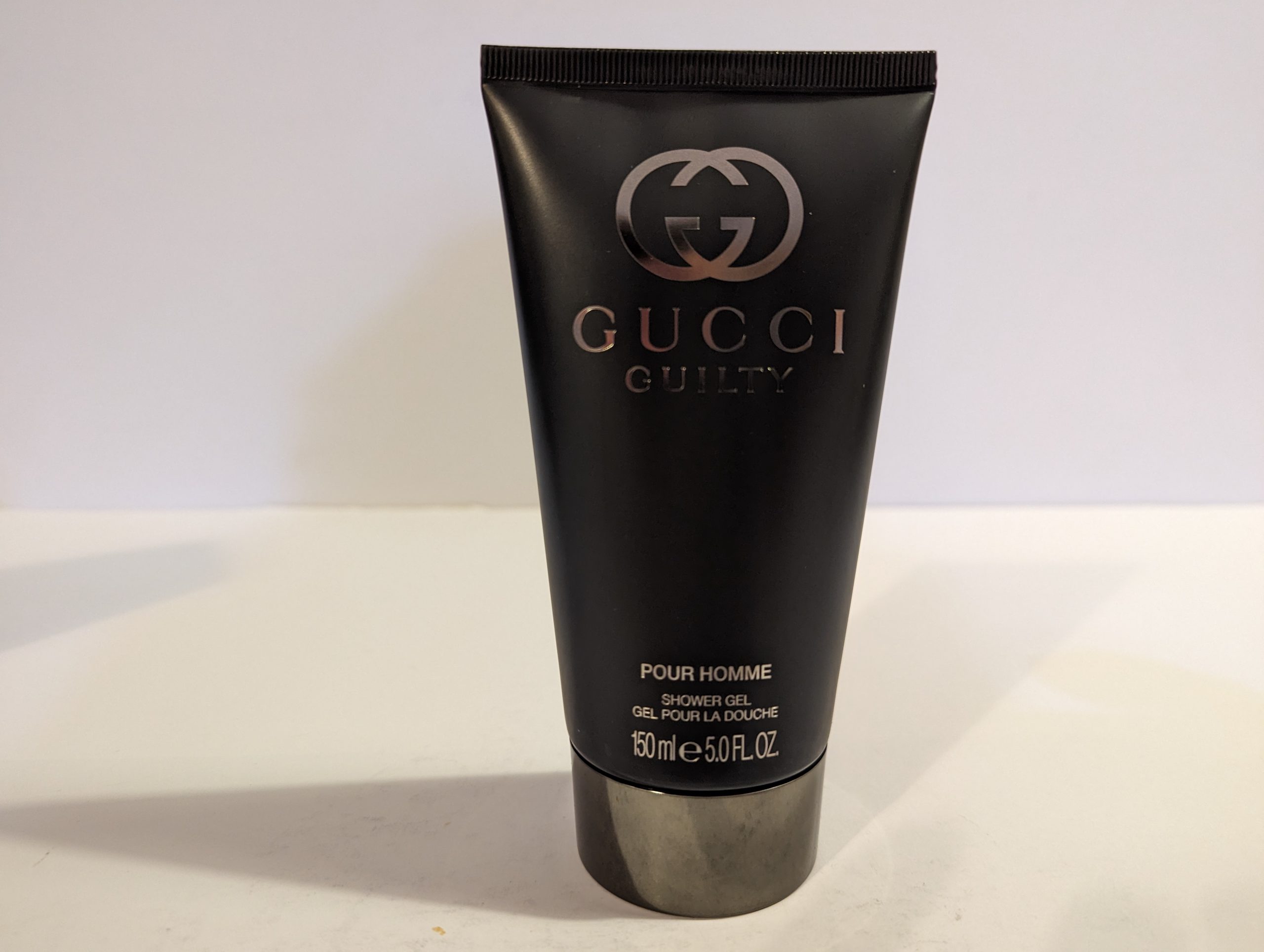 A tube of Gucci Guilty 150ml Shower Gel Body Wash for Men on a white surface.