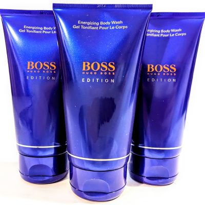 Three bottles of Hugo Boss energizing body wash on a reflective surface. Buy online.