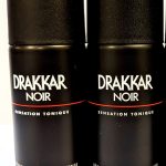 Three bottles of drakkar noir deodorant on a white surface.