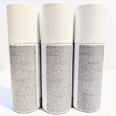 Three white spray cans on a white surface.