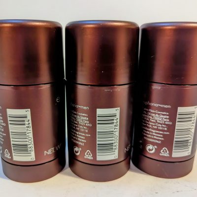 Three brown cylindrical deodorant sticks are placed side by side with their backs facing the camera, displaying the product labels and barcodes.