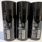 Three black aerosol spray cans of deodorant are lined up side by side with their back labels and barcodes visible.