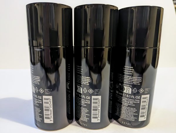 Three black aerosol spray cans of deodorant are lined up side by side with their back labels and barcodes visible.