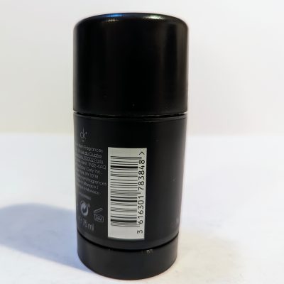 Black cylindrical deodorant container with a label, bar code, and text indicating ingredients and details.