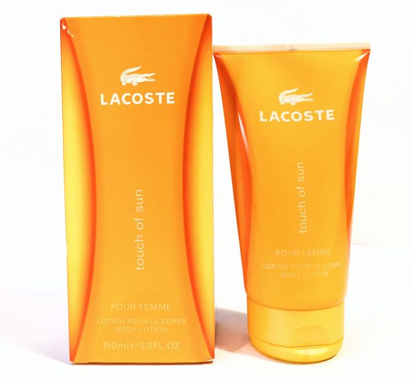 Lacoste "Touch of Sun" body lotion in a 150 ml orange tube, displayed with its matching orange box featuring the Lacoste logo and product name.
