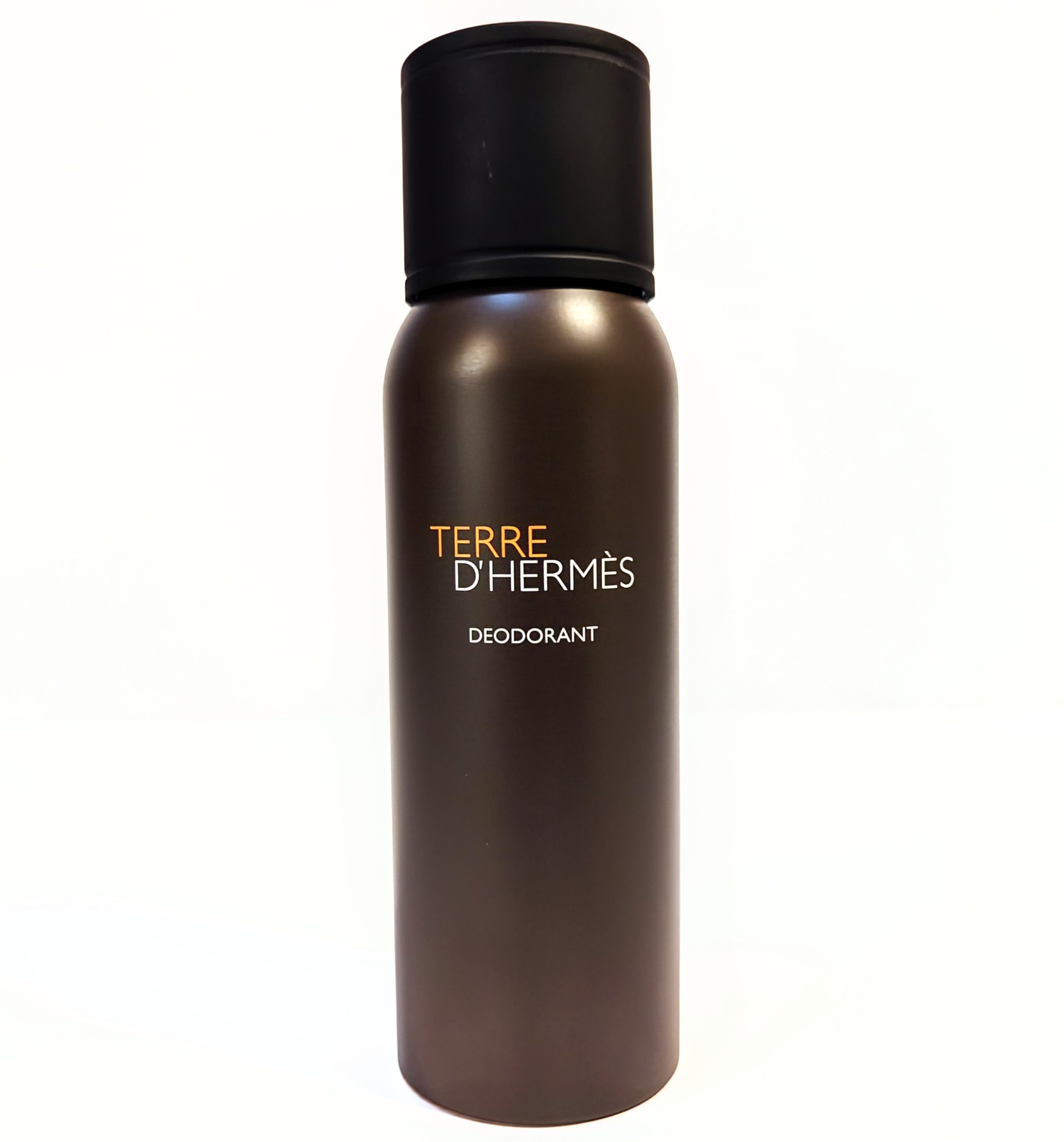 A cylindrical, bronze-colored can of Terre d’Hermès deodorant with a black cap. The text on the can reads, “TERRE D’HERMÈS DEODORANT.