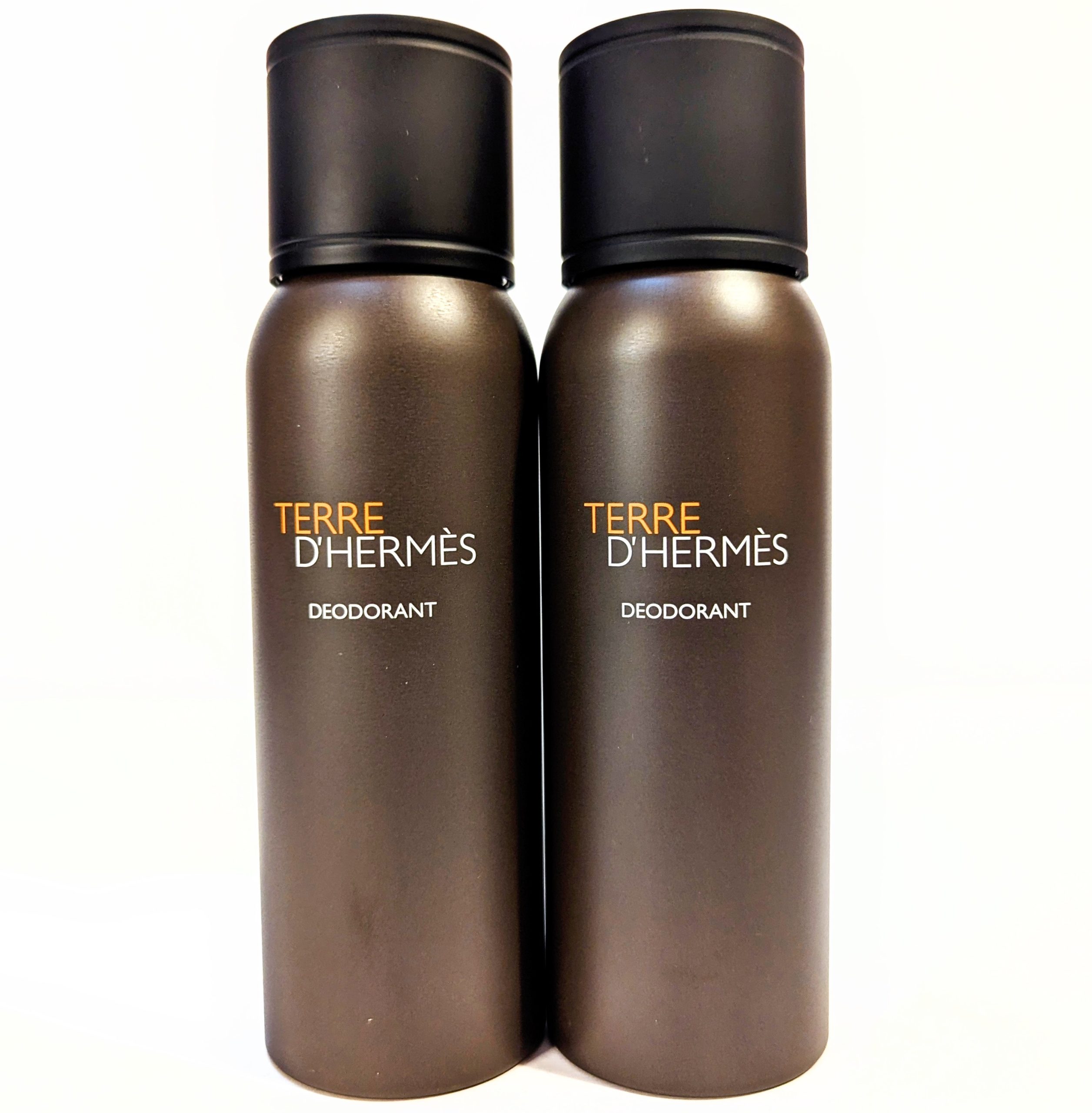 Two brown and black aerosol deodorant bottles with “Terre d’Hermès DEODORANT” written on the front.
