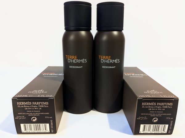 Two black bottles of Hermès Terre d'Hermès deodorant are placed upright between their boxes. The text on the bottles and boxes describes the product details.