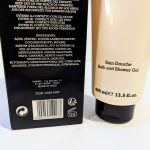 Close-up of a beige bottle labeled "Bain Douche Bath and Shower Gel" and a black box listing ingredients and product details. The bottle has a capacity of 400 ml (13.5 fl oz).