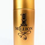A gold-colored spray bottle labeled "1 Million" with an ornate design on the front.