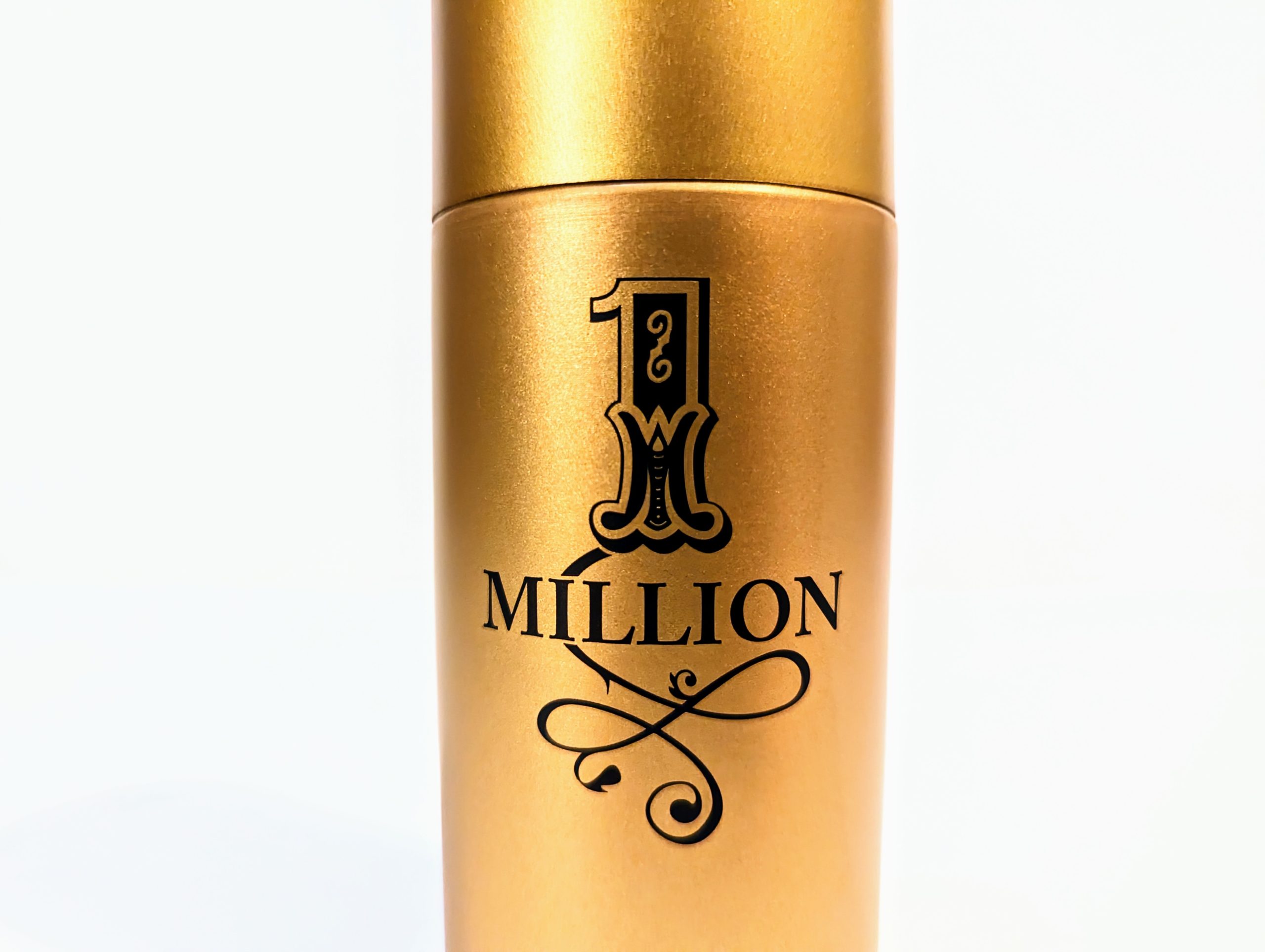 A gold-colored spray bottle labeled “1 Million” with an ornate design on the front.
