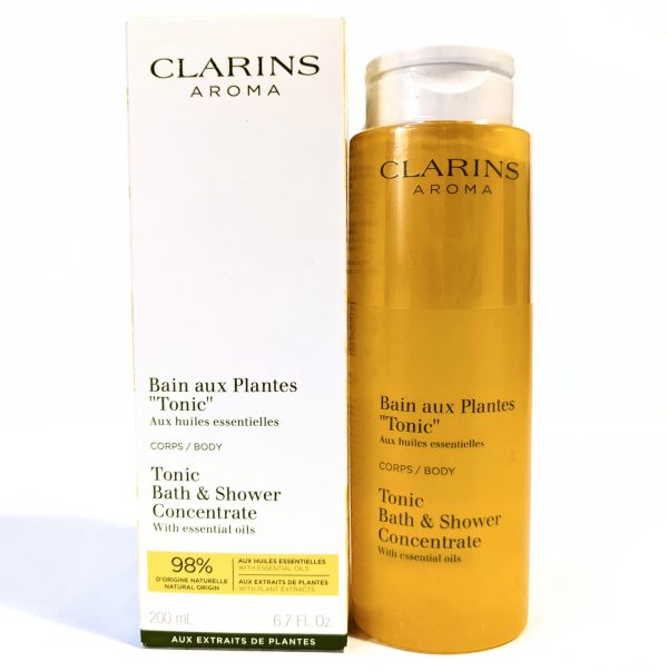 Clarins Aroma Tonic Bath & Shower Concentrate with essential oils, 200 ml bottle, shown next to its packaging box. Clarins Aroma Tonic Bath & Shower Concentrate with essential oils, 200 ml bottle, shown next to its packaging box.
