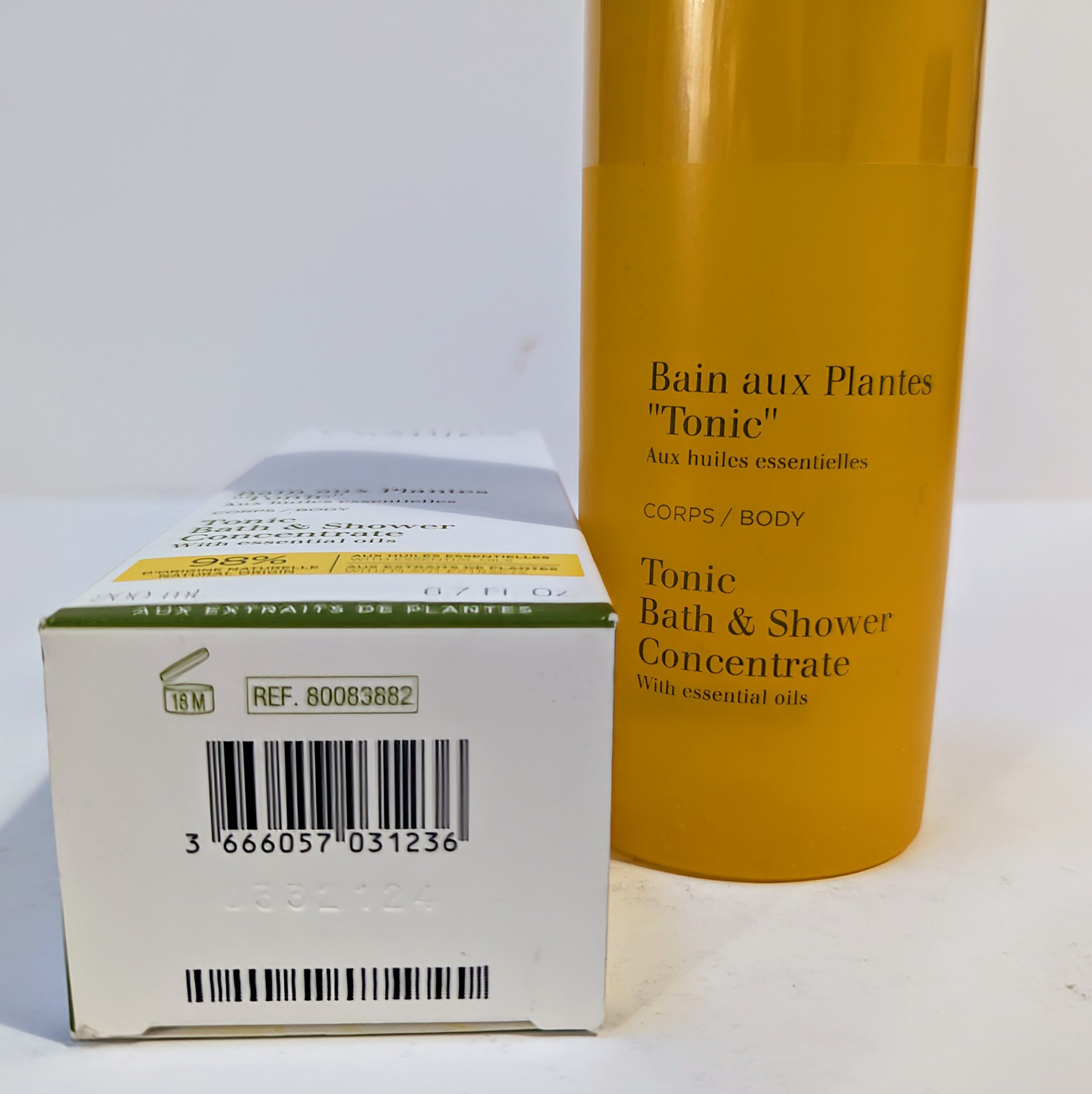 An image of a white box with product information next to a cylindrical yellow bottle labeled “Bain aux Plantes ‘Tonic’ – Tonic Bath & Shower Concentrate with essential oils.