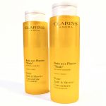 Two yellow bottles of Clarins Aroma Tonic Bath & Shower Concentrate with essential oils, labeled in French and English, placed side by side against a plain white background.