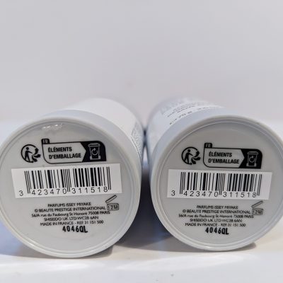 Bottom view of two cylindrical products with labels showing barcodes, recycling symbols, and text indicating "Éléments D'emballage" and product information.