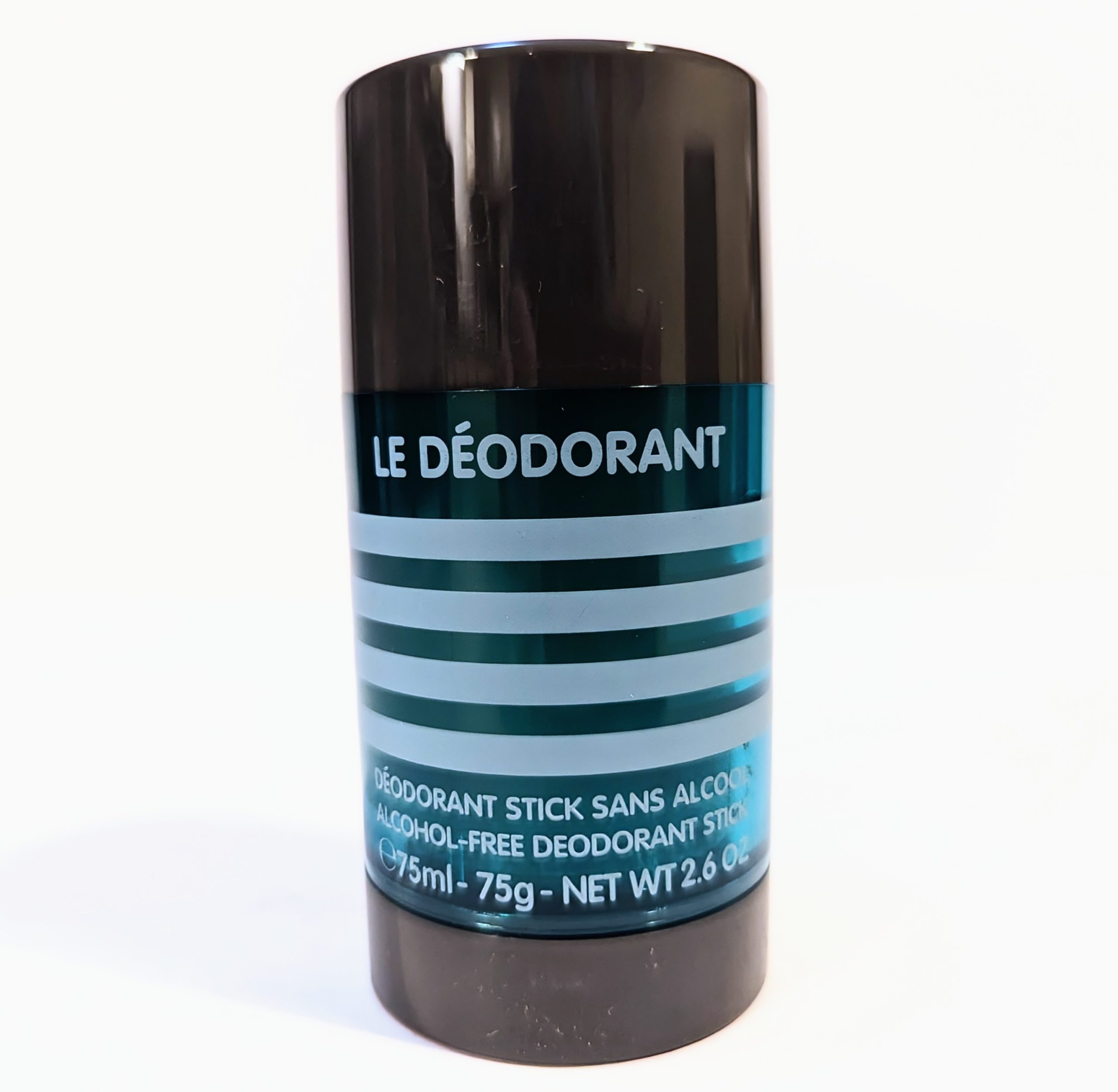 A black cylindrical deodorant stick labeled "Le Déodorant" in blue and white text, noting it is alcohol-free.