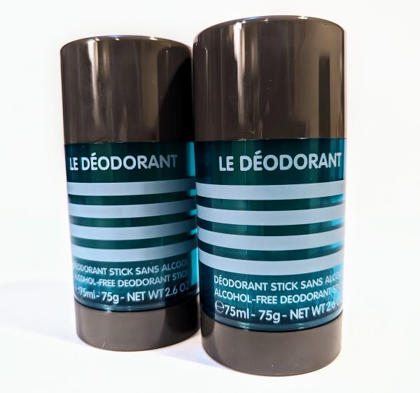 Two black deodorant sticks with teal labels displaying the product name "Le Déodorant" and information including "Alcohol-Free" and "Net Wt 2.6 oz / 75ml.