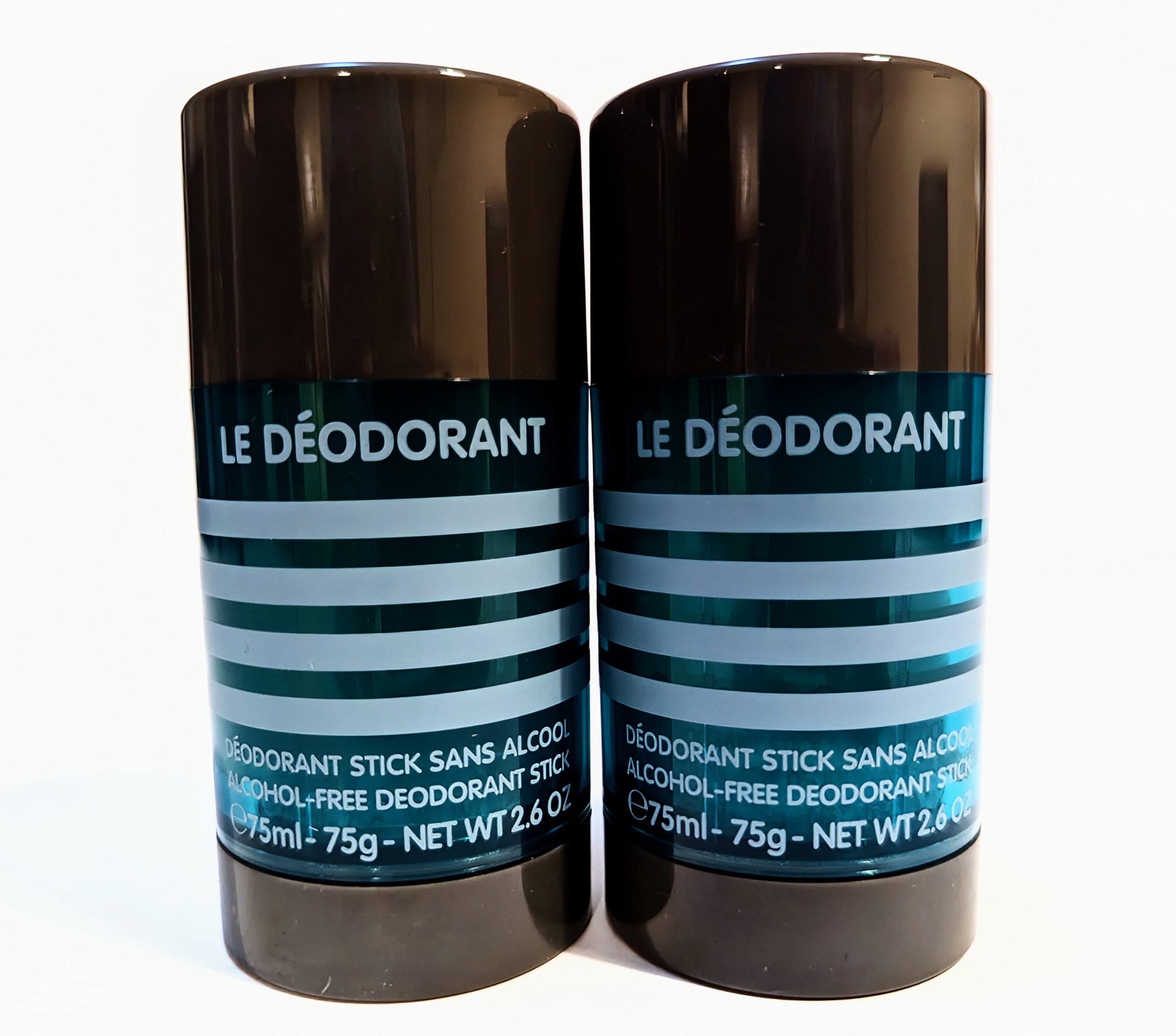 Two black cylindrical containers of “Le Déodorant,” labeled as alcohol-free deodorant sticks, each containing 75 ml (2.6 oz) of product.