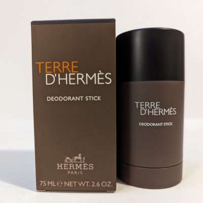 A 75 ml Terre D'Hermès deodorant stick is placed beside its brown packaging box on a plain background.