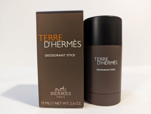 A 75 ml Terre D'Hermès deodorant stick is placed beside its brown packaging box on a plain background.