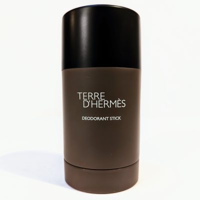 A Terre D'Hermès deodorant stick in a cylindrical, dark brown container with a black cap, standing upright against a white background.