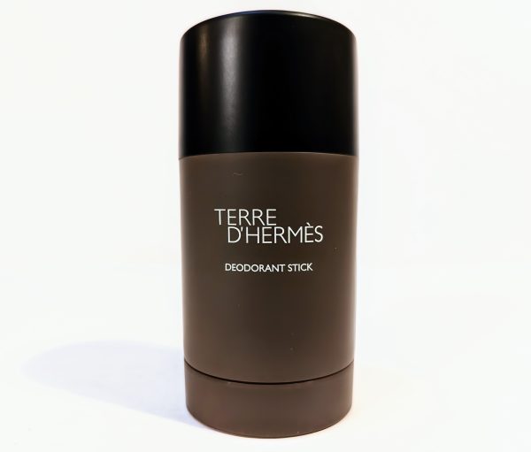 A Terre D'Hermès deodorant stick in a cylindrical, dark brown container with a black cap, standing upright against a white background.