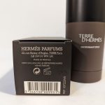 A box labeled "HERMÈS PARFUMS" and a "TERRE D'HERMÈS" deodorant stick are displayed. The packaging includes product details and a barcode.