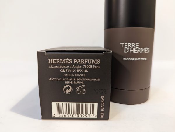 A box labeled "HERMÈS PARFUMS" and a "TERRE D'HERMÈS" deodorant stick are displayed. The packaging includes product details and a barcode.
