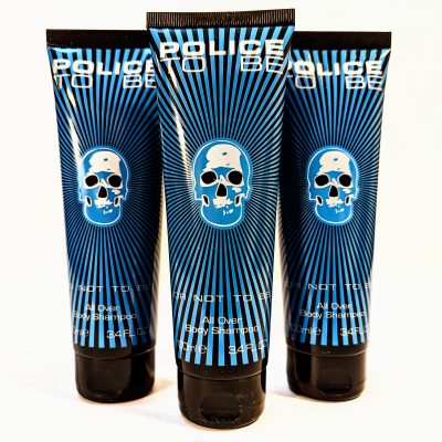 Three tubes of "Police To Be" all-over body shampoo with a blue skull design on the packaging, each containing 3.4 fluid ounces.