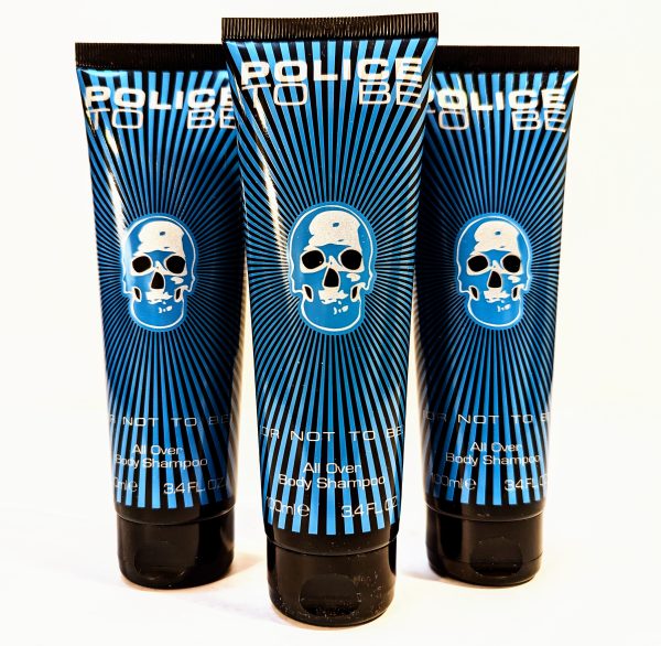 Three tubes of "Police To Be" all-over body shampoo with a blue skull design on the packaging, each containing 3.4 fluid ounces.