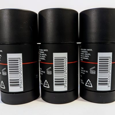 Three black deodorant bottles are shown in a row with barcodes, recycling, and ingredient information visible on the back labels.