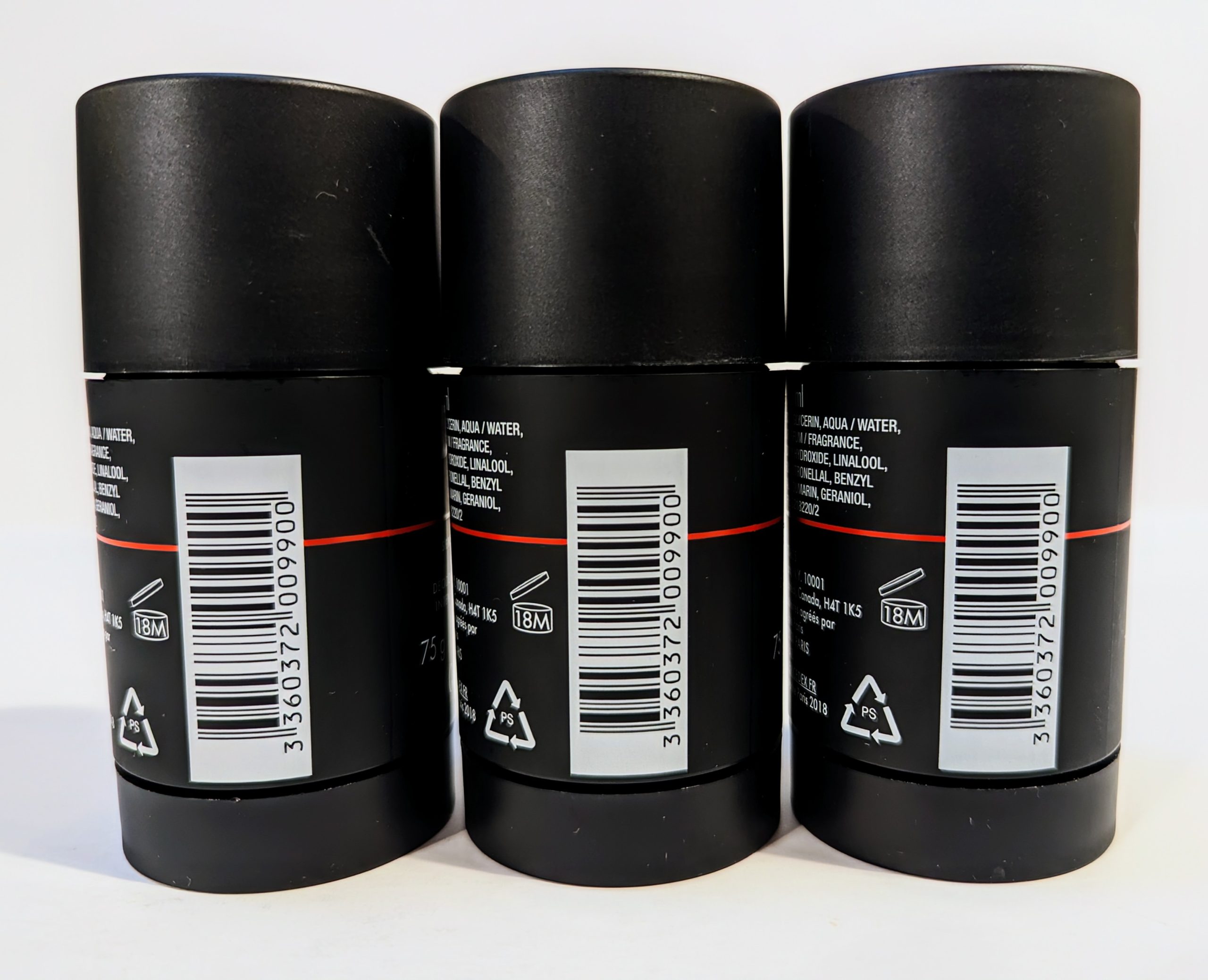 Three black deodorant bottles are shown in a row with barcodes, recycling, and ingredient information visible on the back labels.